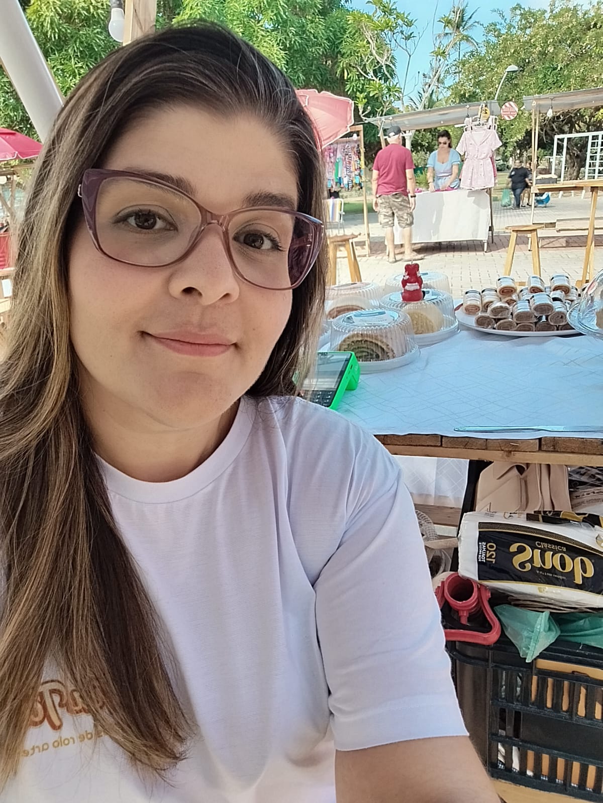 Fundadora da Tia Táta na feira artesanal, ao lado dos bolos de rolo
